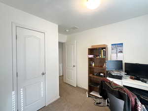 Carpeted office space with a textured ceiling