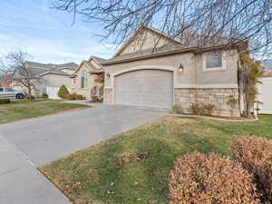 View of front of property with a garage and a front lawn