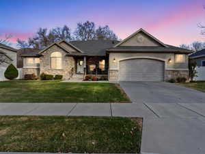 View of front facade with a yard and a garage