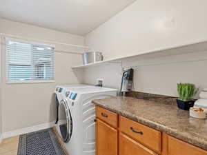 Laundry area with washer and dryer and light tile patterned floors