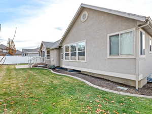 View of side of property with a lawn