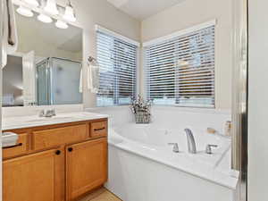 Bathroom featuring tile patterned flooring, vanity, and independent shower and bath