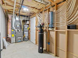 Utility room featuring heating unit and water heater