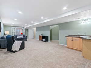 Carpeted living room with sink and french doors