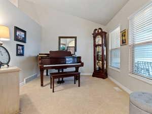 Interior space with light colored carpet and vaulted ceiling