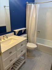 Full bathroom with shower / bath combo, vanity, and toilet