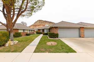 Ranch-style home featuring a front yard and a garage