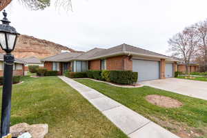 Ranch-style home featuring a front yard and a garage