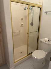 Bathroom with a shower with door and toilet