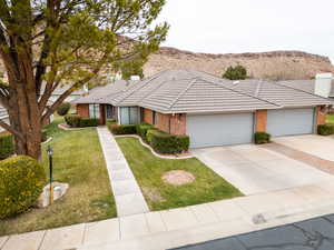 Single story home featuring a mountain view, a front lawn, and a garage