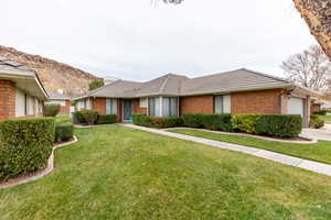 Ranch-style home with a front lawn and a garage