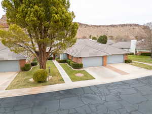 View of front of home with a mountain view, a garage, and a front lawn