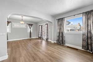 Empty room featuring hardwood / wood-style floors and a textured ceiling