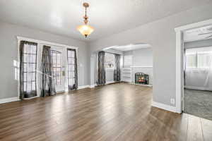 Unfurnished living room with a textured ceiling and dark hardwood / wood-style floors