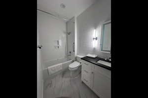 Full bathroom featuring vanity, toilet, and tiled shower / bath