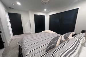 Bedroom featuring light colored carpet and a closet