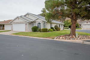 Single story home with a garage and a front yard