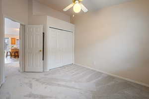 Unfurnished bedroom featuring ceiling fan, light carpet, and a closet