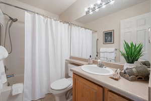 Full bathroom with vanity, toilet, and shower / bath combo with shower curtain