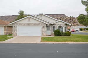 Single story home featuring a mountain view, a garage, and a front yard