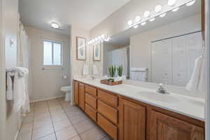 Bathroom featuring tile patterned flooring, vanity, a textured ceiling, and toilet