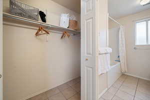 Spacious closet featuring light tile patterned flooring