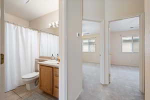 Bathroom with tile patterned floors, a wealth of natural light, vanity, and toilet