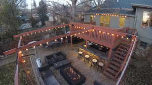 Exterior space featuring a wooden deck, a bar, and a fire pit