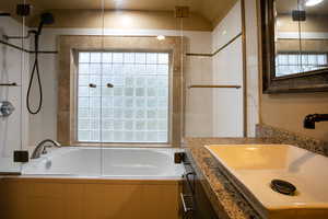 Bathroom featuring vanity, lofted ceiling, and independent shower and bath