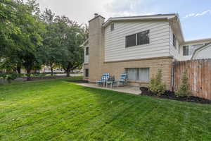 Rear view of house with a patio and a lawn