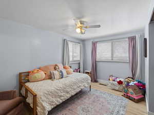 Bedroom with ceiling fan and light wood-type flooring