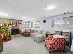 Living room with carpet, a fireplace, and a wealth of natural light