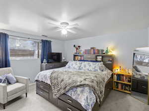 Bedroom featuring multiple windows, ceiling fan, and light carpet