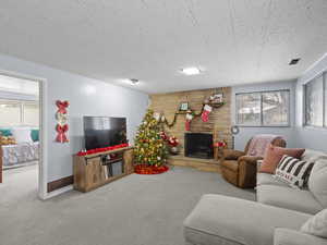 Living room with carpet flooring, a fireplace, and wood walls