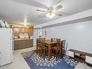 Dining room with a textured ceiling, ceiling fan, and sink