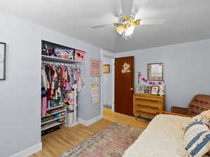 Bedroom featuring ceiling fan, a closet, and light hardwood / wood-style floors