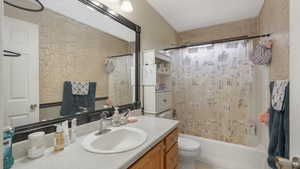 Full bathroom featuring shower / tub combo, vanity, and toilet