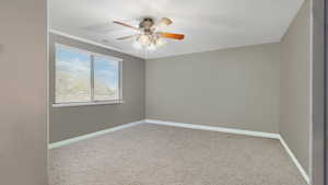 Carpeted spare room with ceiling fan