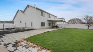 Rear view of house featuring a yard and a patio