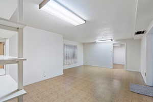 Interior space with a textured ceiling and light parquet flooring