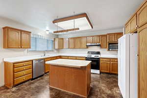 Kitchen featuring sink, a kitchen island, and stainless steel appliances