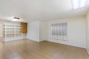 Basement with a textured ceiling and light parquet flooring