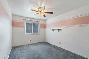 Unfurnished room featuring carpet floors and ceiling fan