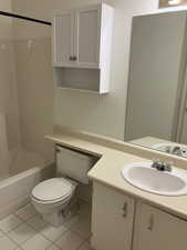 Full bathroom featuring tile patterned floors, vanity, toilet, and tub / shower combination