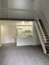 Unfurnished living room featuring carpet floors and sink