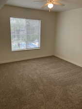 Empty room featuring carpet and ceiling fan