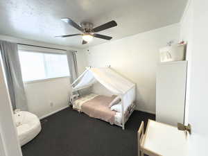 Carpeted bedroom with ceiling fan and crown molding