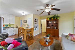 Living room with ceiling fan and dark hardwood / wood-style flooring