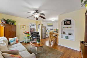 Living room with hardwood / wood-style flooring and ceiling fan