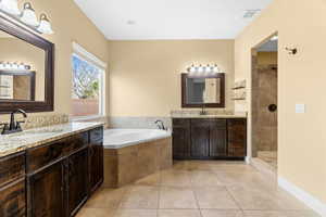 Bathroom with tile patterned flooring, vanity, and independent shower and bath